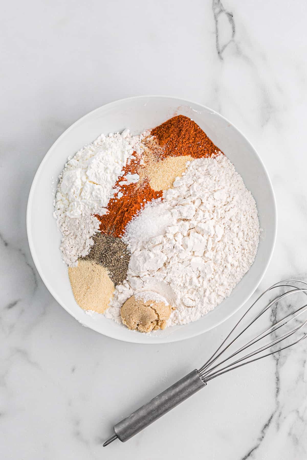 Flour and seasonings in a shallow white bowl.