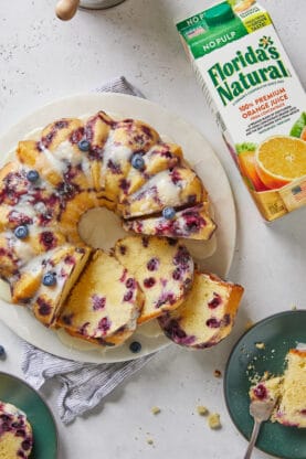 A bundt cake with slices cut out showing blueberries in them