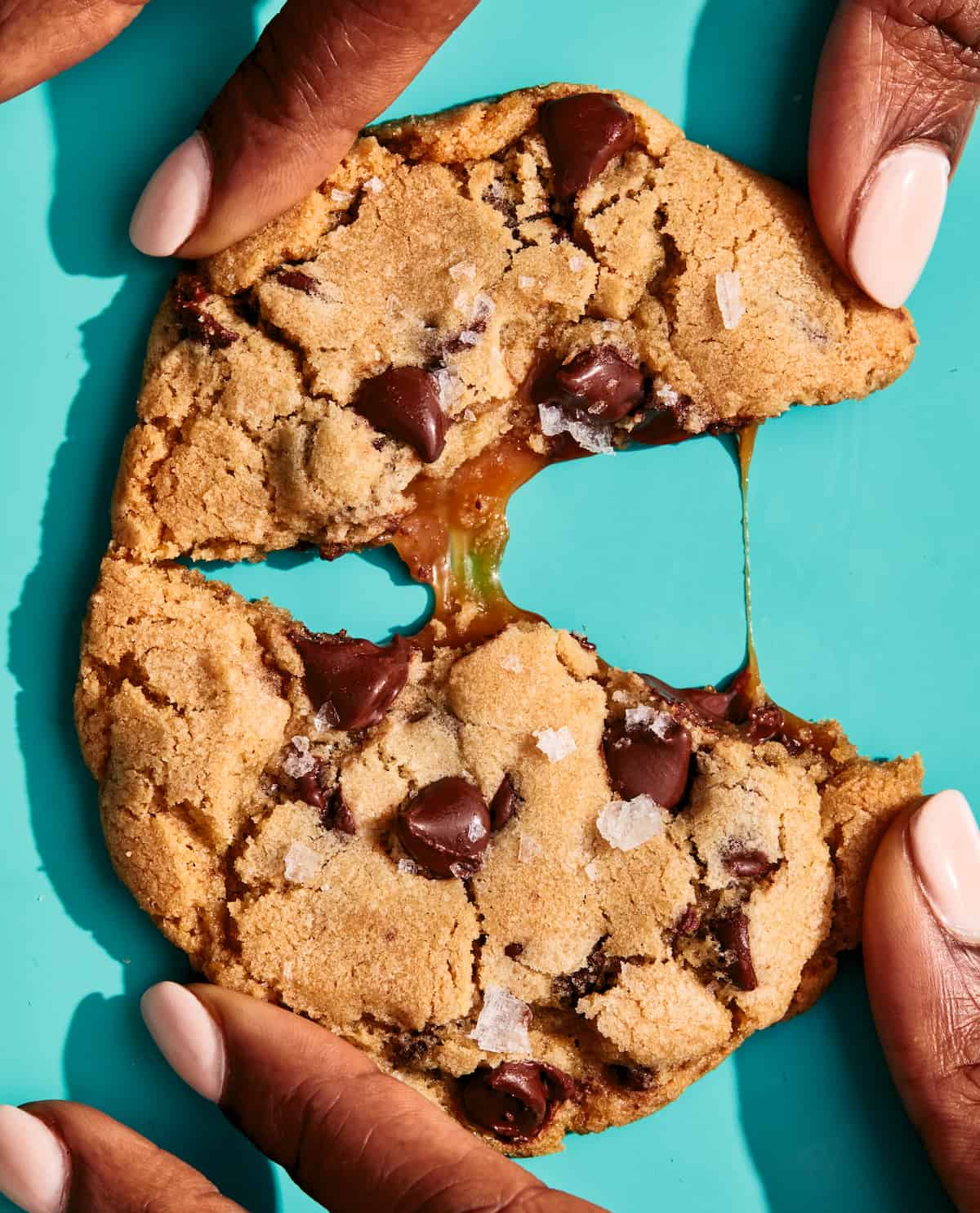 Salted Caramel Chocolate Chip Cookie being pulled in half.