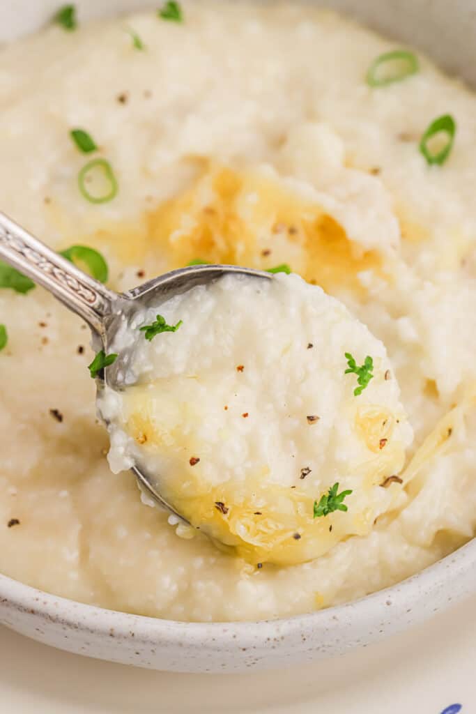 Close up of a spoonful of cheese grits.