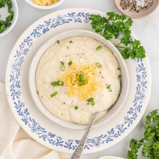 Fresh bowl of cheese grits served with a spoon