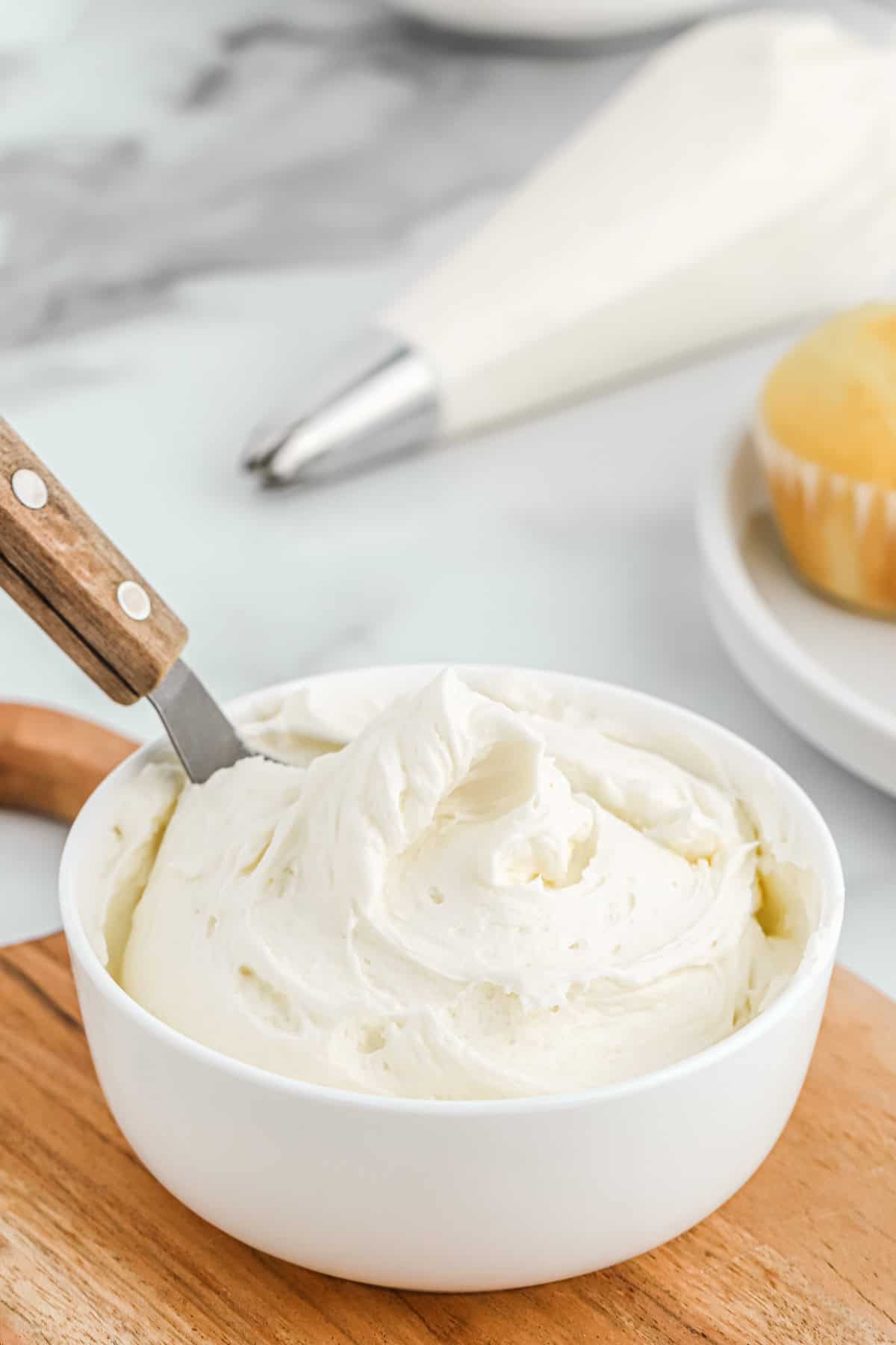 American butter cream in a white bowl with a piping bag in the background