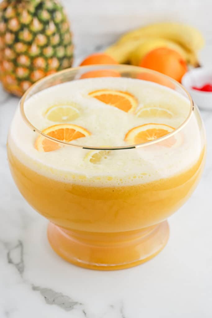 Overhead of fully made fruit punch bowl filled with sliced oranges.