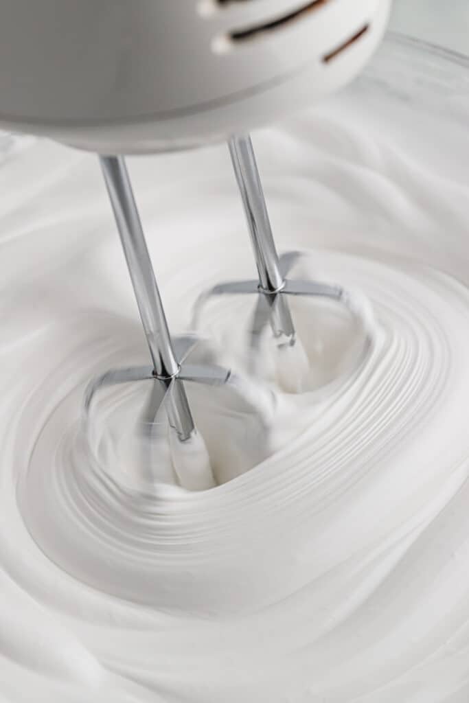 A hand mixer whipping the frosting.
