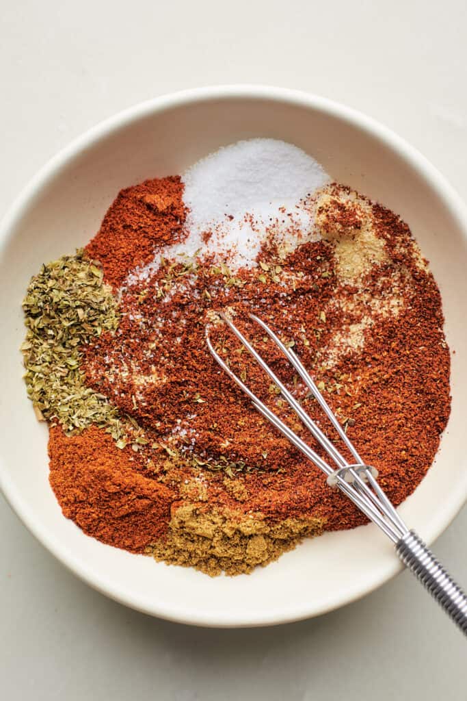 Fajita spices in a large bowl with a whisk