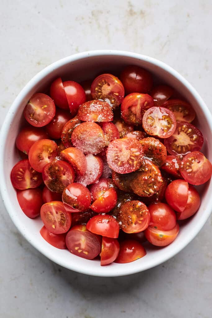 Cherry tomatoes sliced in a large bowl