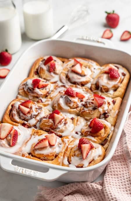 Strawberry shortcake cinnamon rolls ready to serve in baking dish