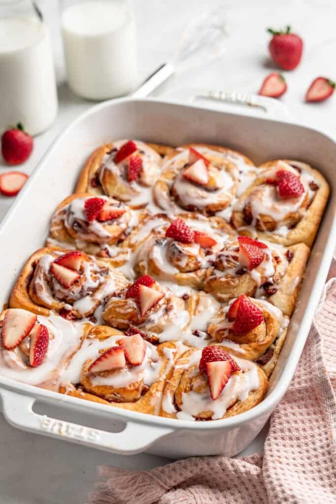 Strawberry shortcake cinnamon rolls ready to serve in baking dish