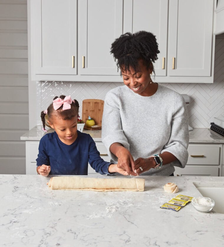 Harmony and Jocelyn Delk Adams rolling cinnamon roll dough together