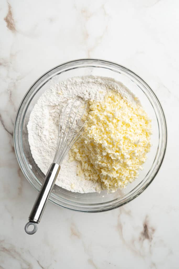 A bowl of flour and grated frozen butter.