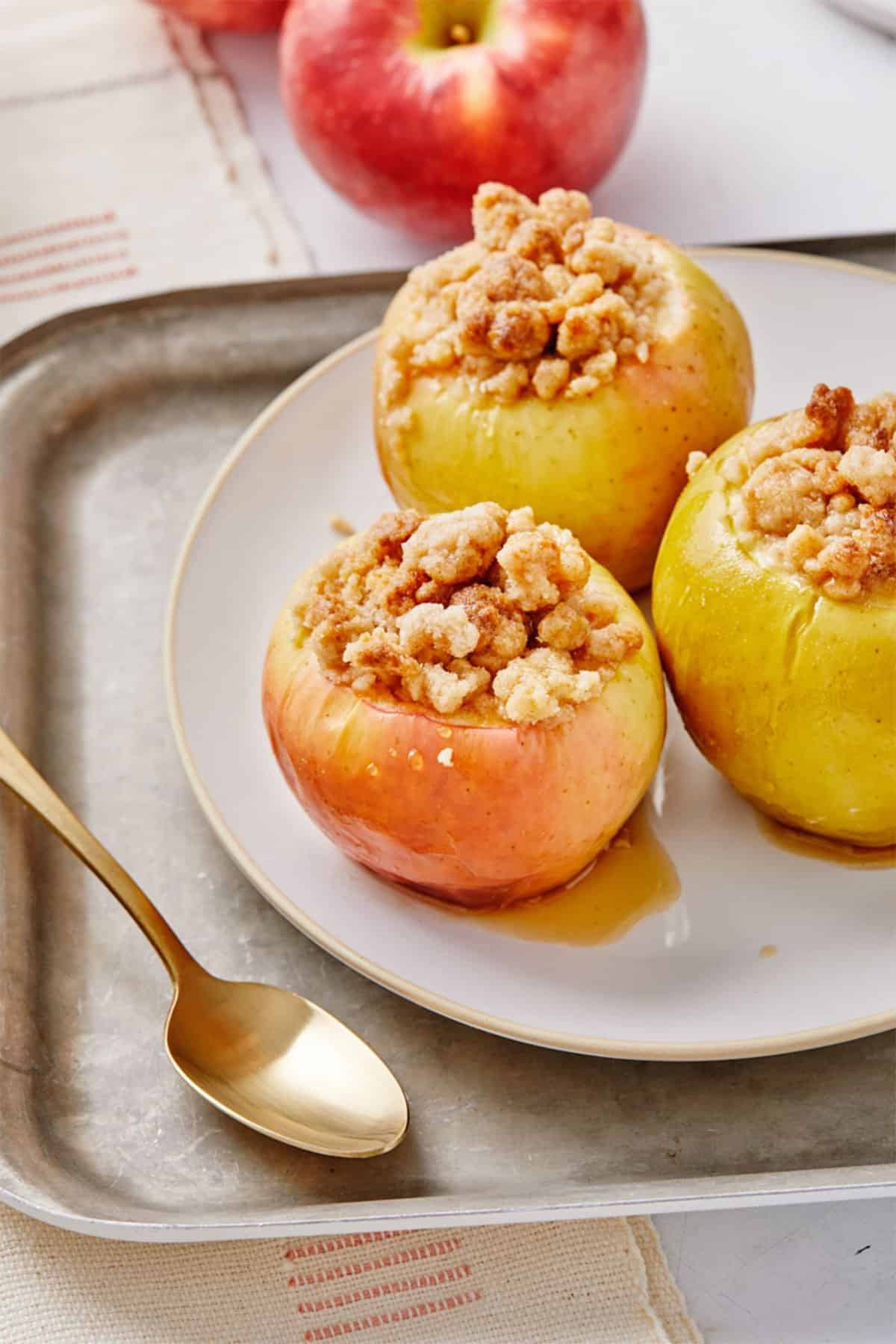 Baked apples with crumb topping on a plate ready to eat.