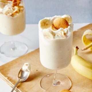 Skinny Banana Pudding Milkshakes in two glasses on baking pan with banana and wafers around