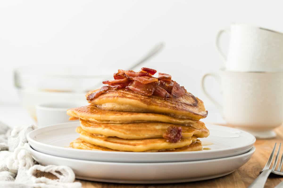 A stack of brown sugar pancakes topped with maple bacon syrup.