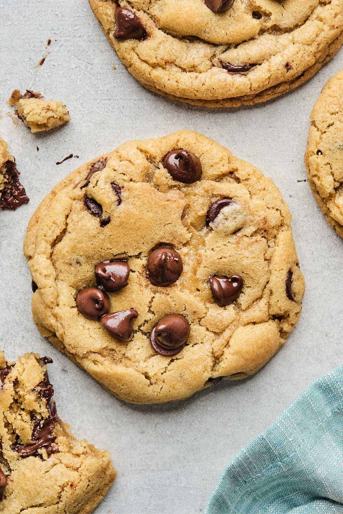 Overhead of BEST chewy chocolate chip cookie in center against white background