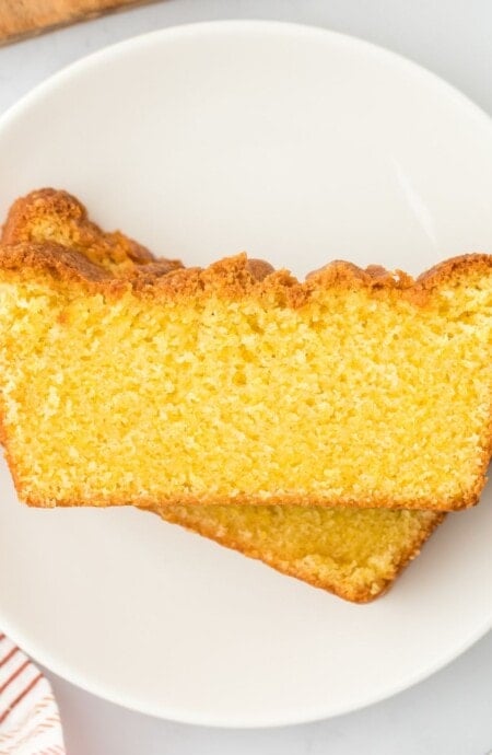 Two slices of cornmeal cake stacked on a plate at slightly different angles.