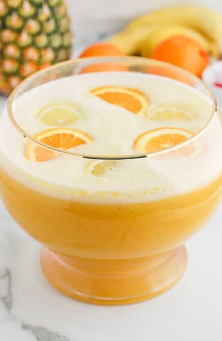 Overhead of fully made fruit punch bowl filled with sliced oranges.