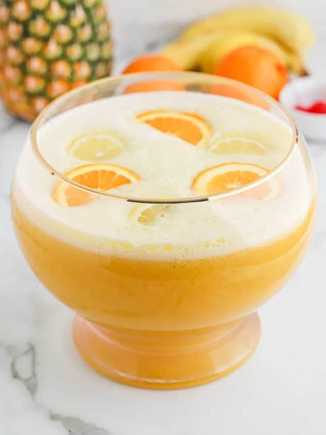 Overhead of fully made fruit punch bowl filled with sliced oranges.