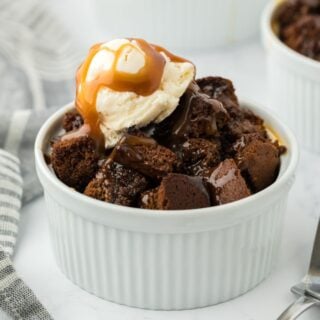 Gingerbread bread pudding in a ramekin topped with ice cream and toffee sauce.