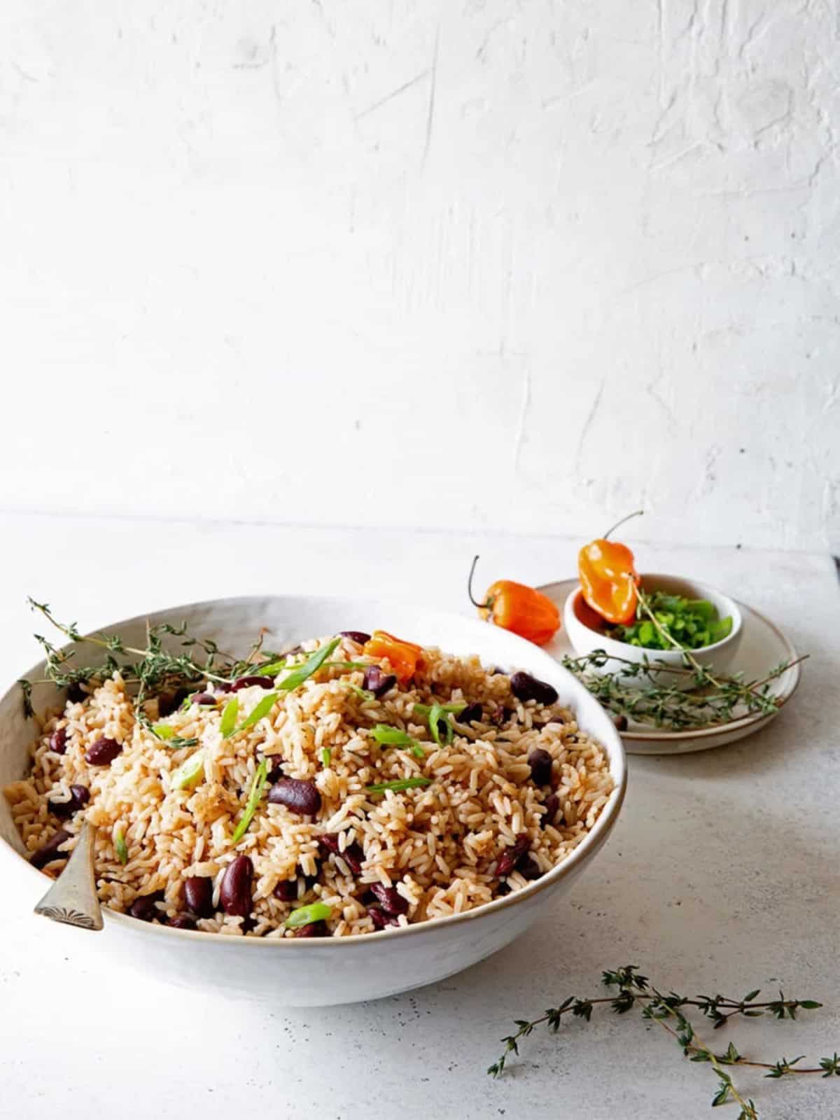 Jamaican Rice and Peas in white bowl against white wall.