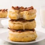 A stack of three maple bacon doughnuts on a plate.