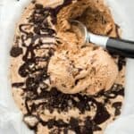 Close up of a tray full of mocha fudge swirl ice cream with a ice cream scoop in it