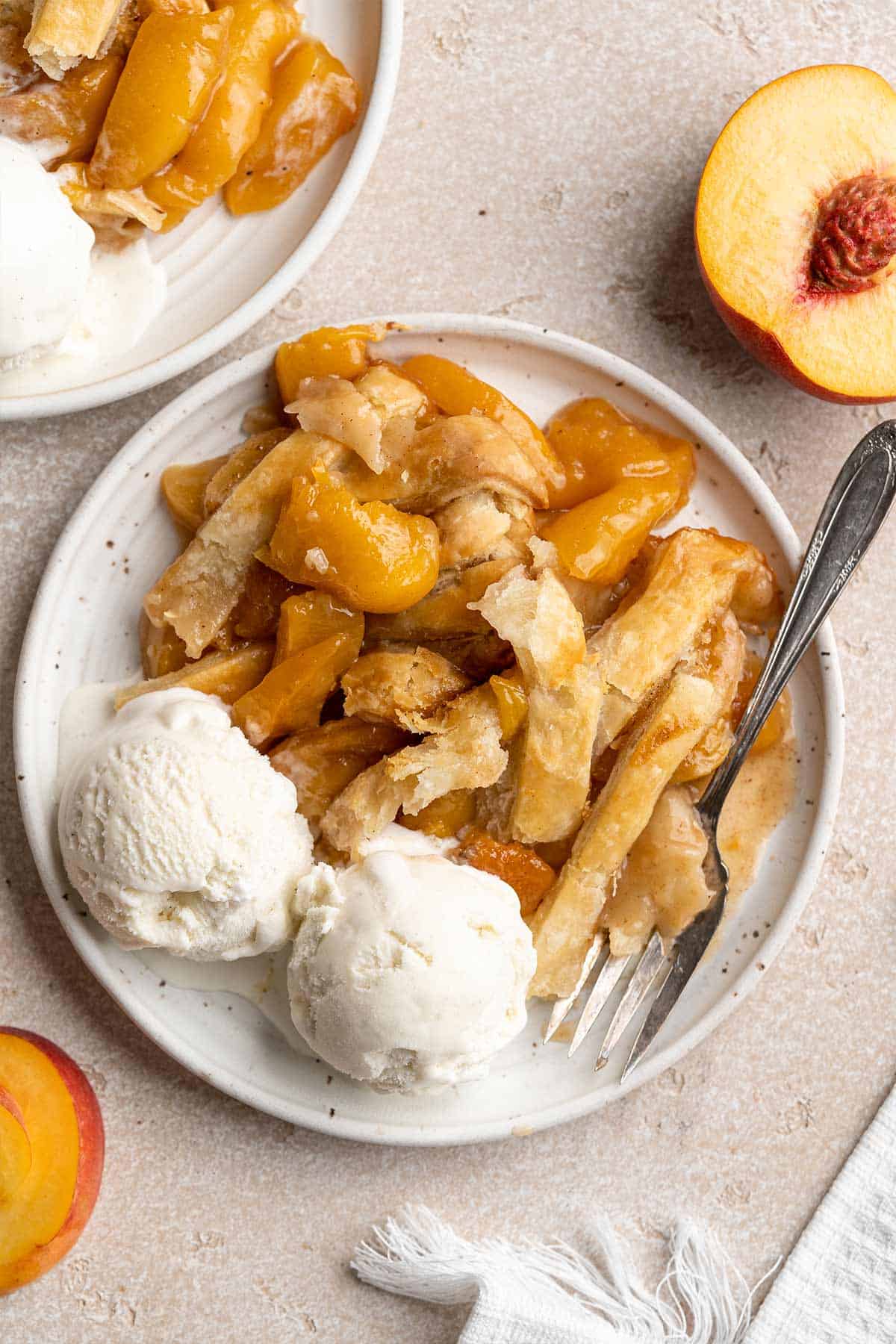 Southern-style cobbler featuring canned and fresh peaches served in a large white cooking dish.