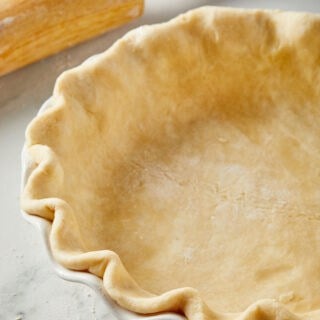 A Perfect Flaky Pie Crust Recipe made with all butter in a pie plate ready to bake