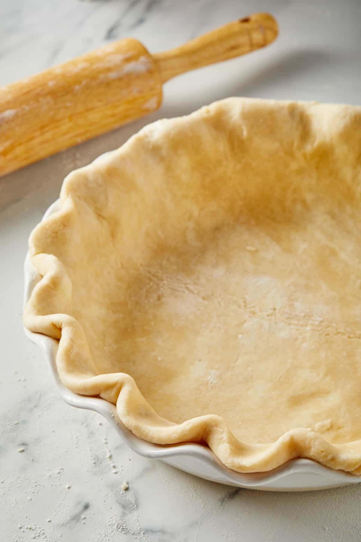 Overhead shot of a Perfect Flaky Pie Crust contained in a white pie plate.