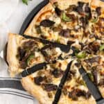 philly cheese steak pizza with slices being pulled with a cheese pull