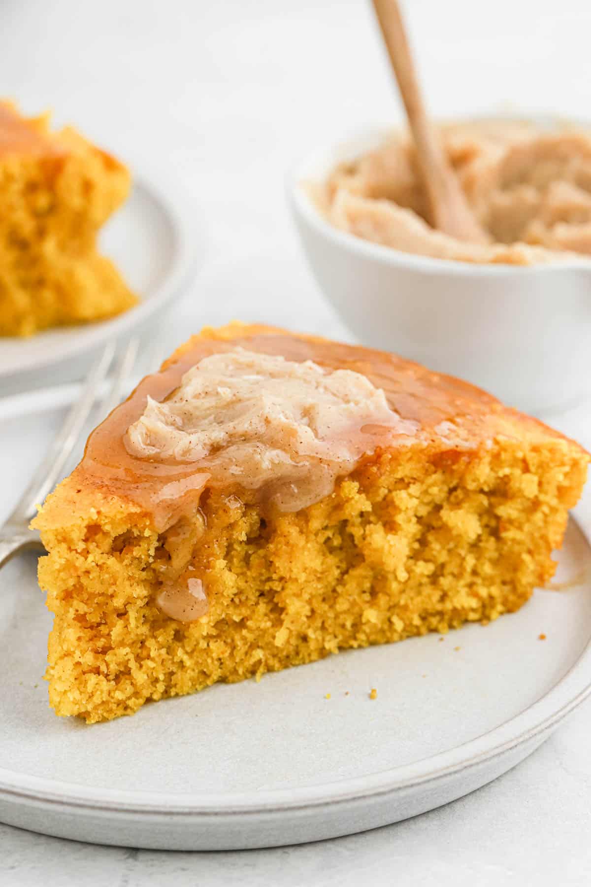 Close up of a slice brown butter pumpkin cornbread topped with butter.
