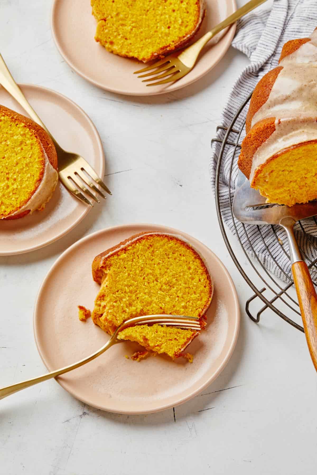 Pumpkin bundt cake sliced on plates with forks on the table.