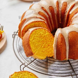 A pumpkin pound cake on a wire rack cut into slices.