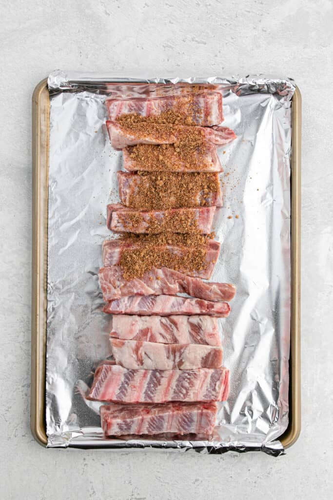 Seasoning being sprinkled on top of ribs