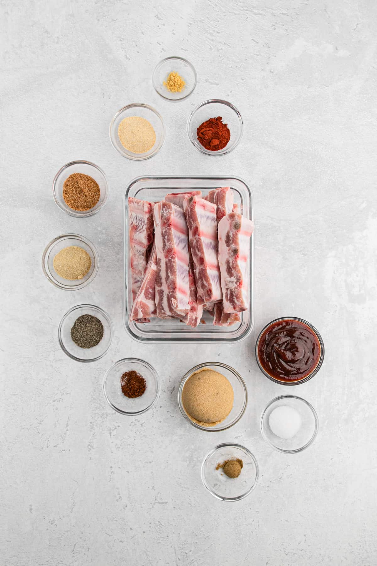 Ingredients to make rib tips in clear bowls on a gray surface area