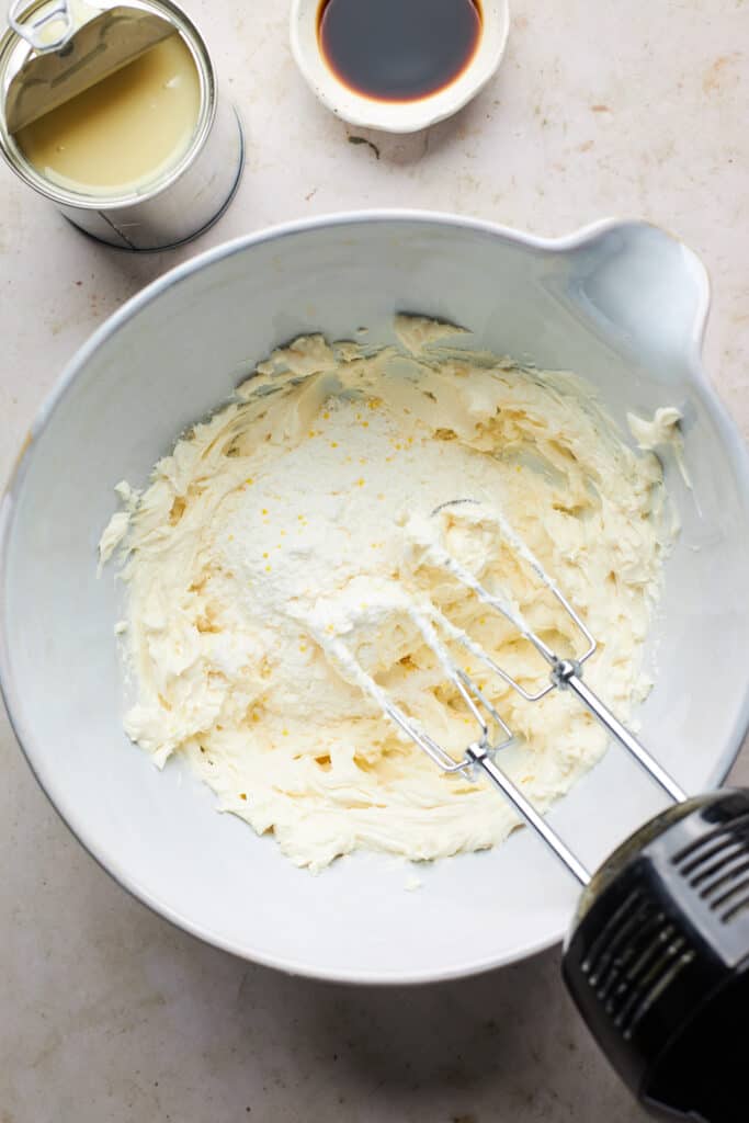 Banana pudding mix being whisked into cream cheese