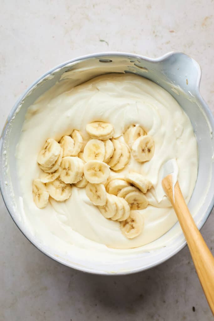 Banana slices being folded into no churn ice cream