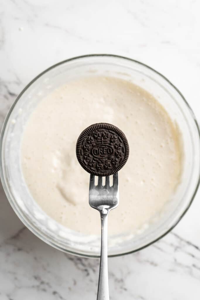 An oreo on a fork before adding to dough batter