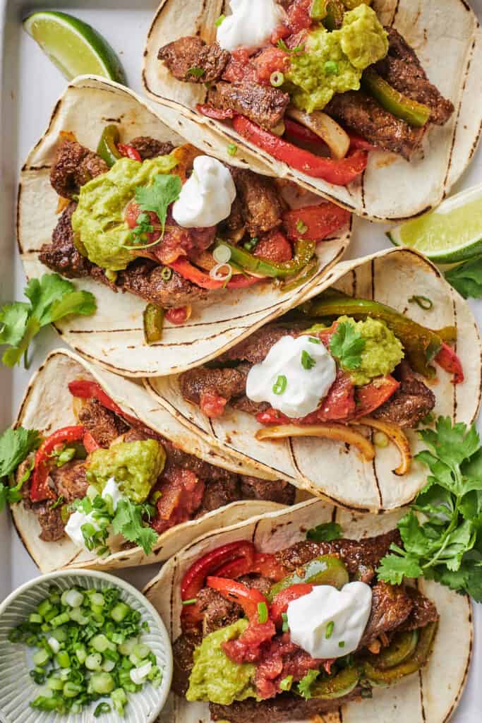 Sheet-pan steak fajitas in tortillas ready to enjoy