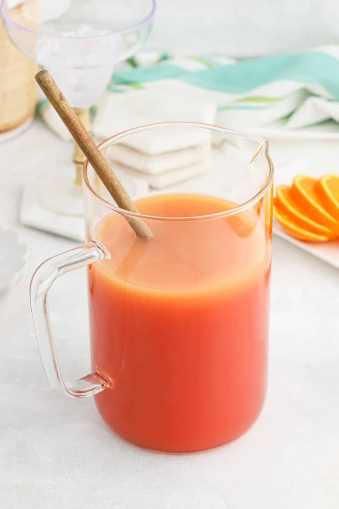 Rum punch being mixed in a pitcher.