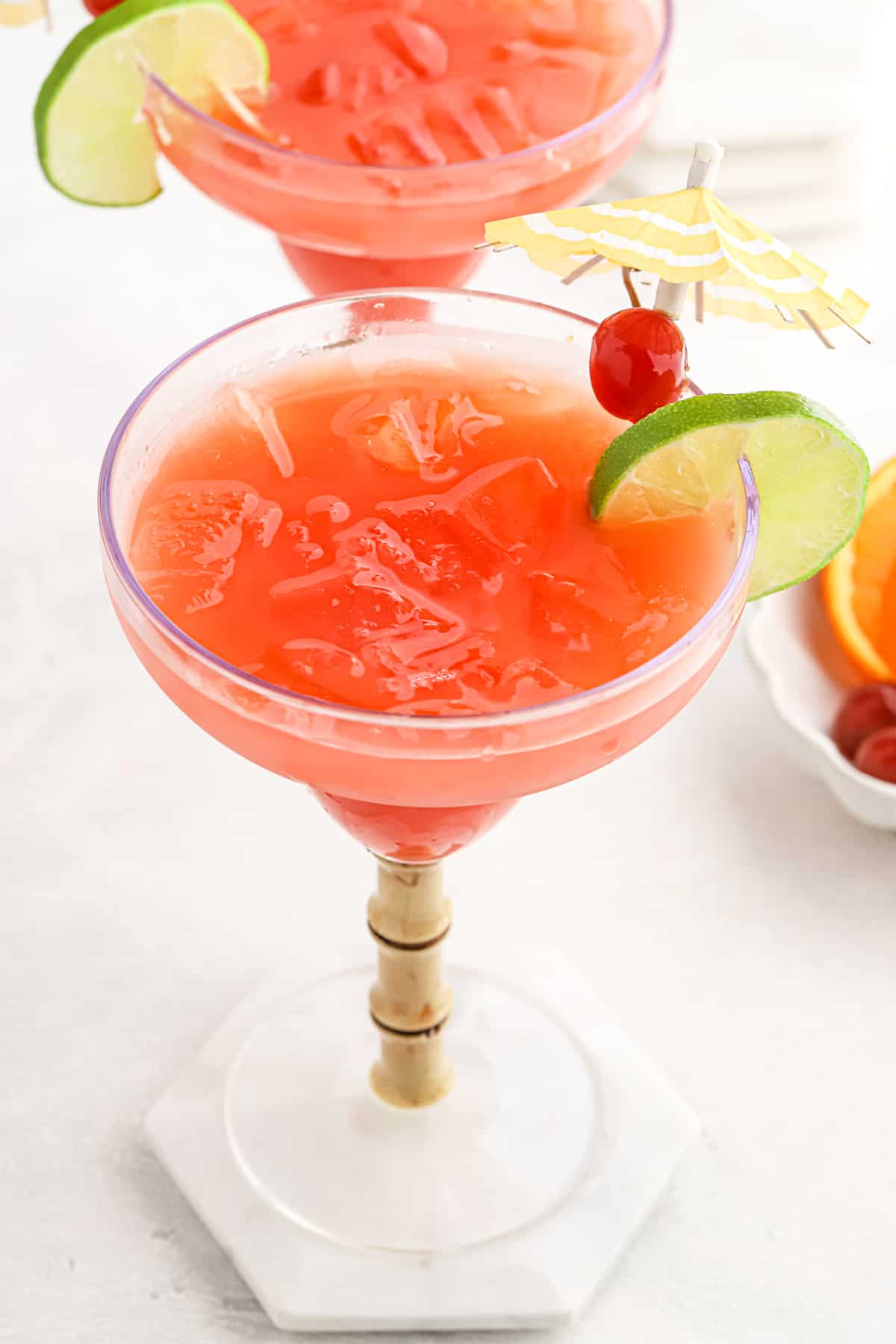 Two cocktail glasses garnished and full of a rum punch recipe.