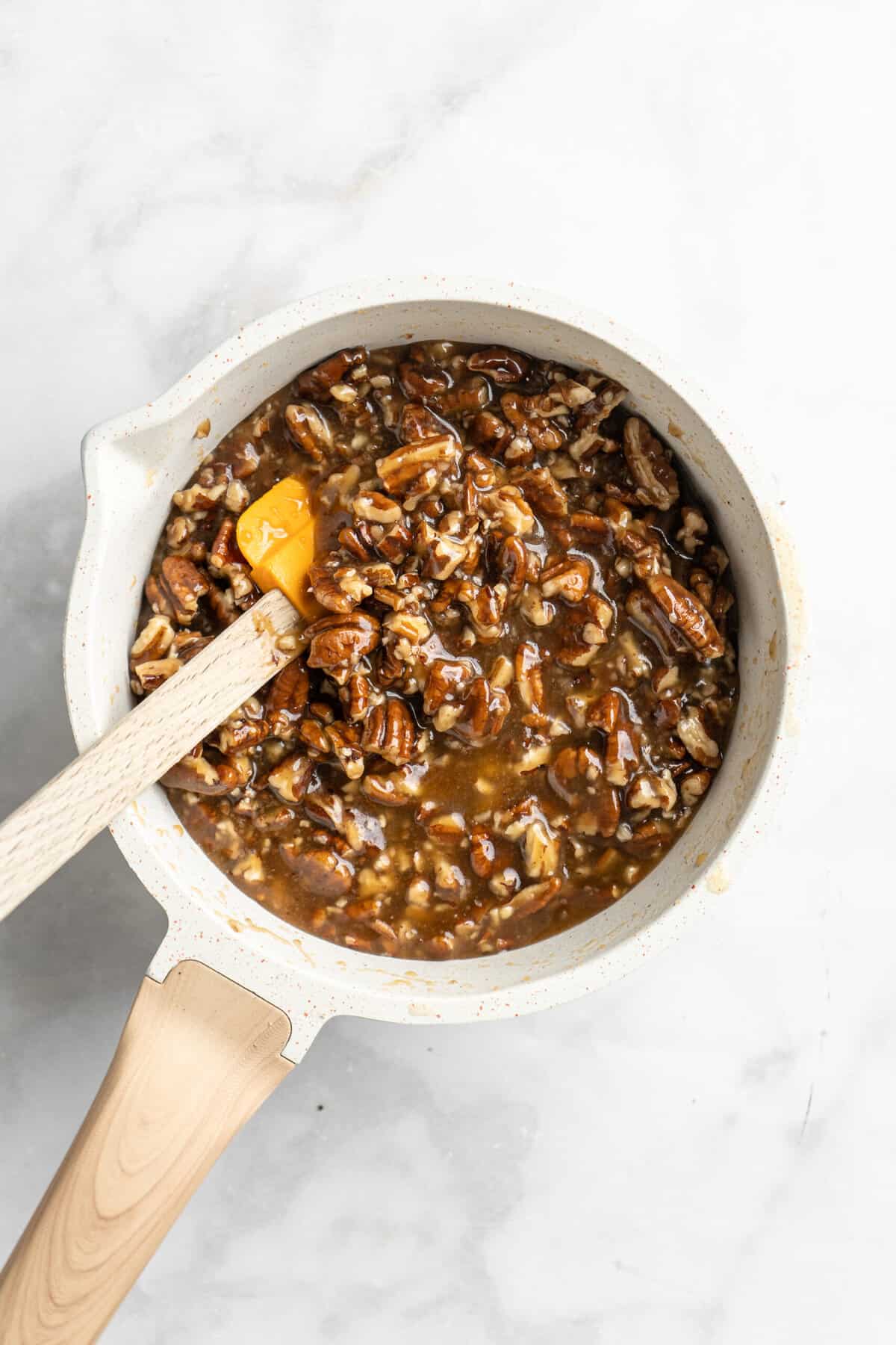 Pecan pie filling and a spatula in a saucepan.