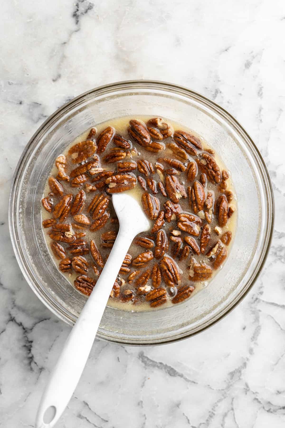 A rubber spatula in a bowl of pecan pie filling.