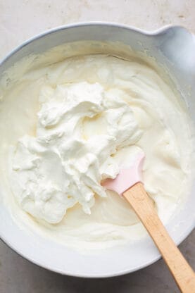 Whipped Heavy cream being folded into cream cheese mixture