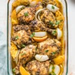 A baking dish of orange herbed baked chicken pieces.