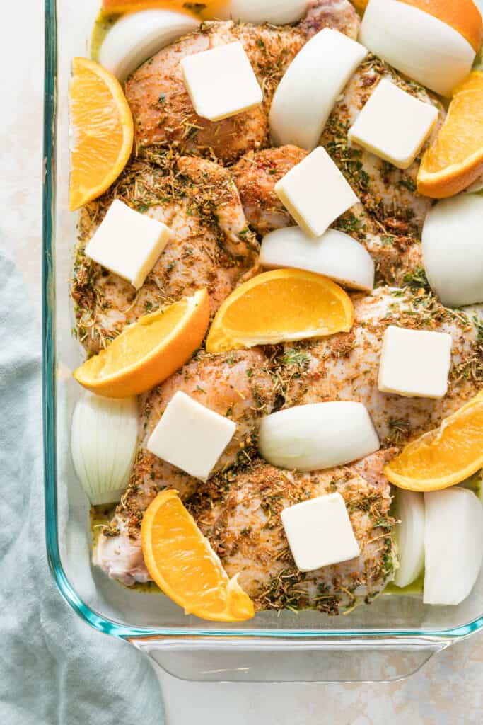 A baking dish of orange herbed baked chicken pieces.