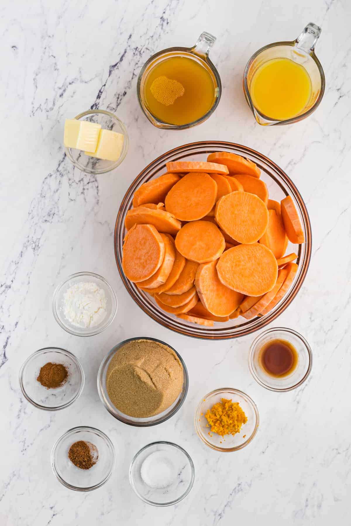 Ingredients to make baked candied yams in small bowls on a white surface