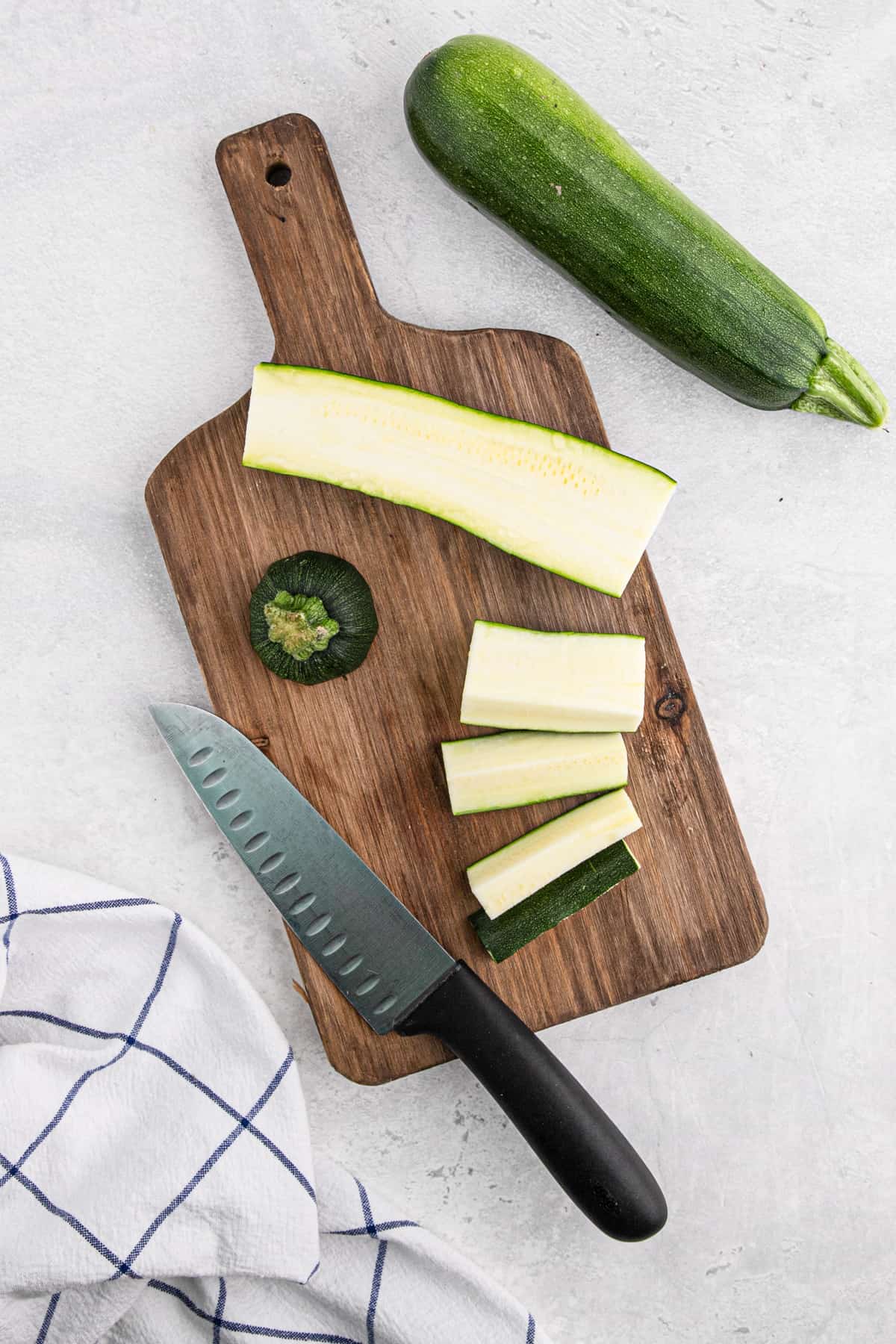Sliced zucchini on a cutting board.