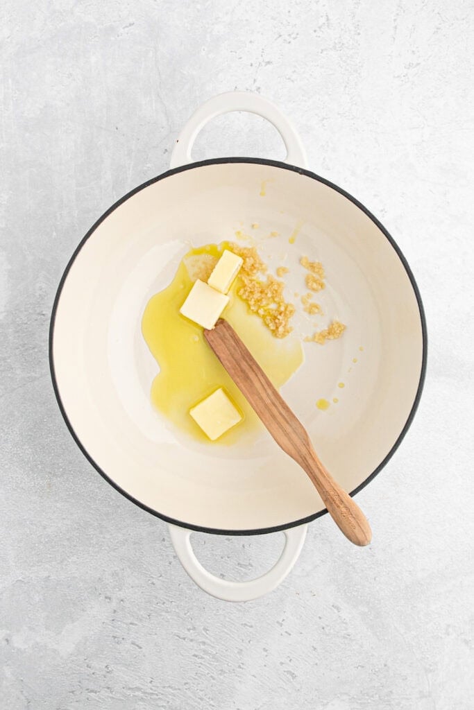 Butter added to a pan with garlic 
