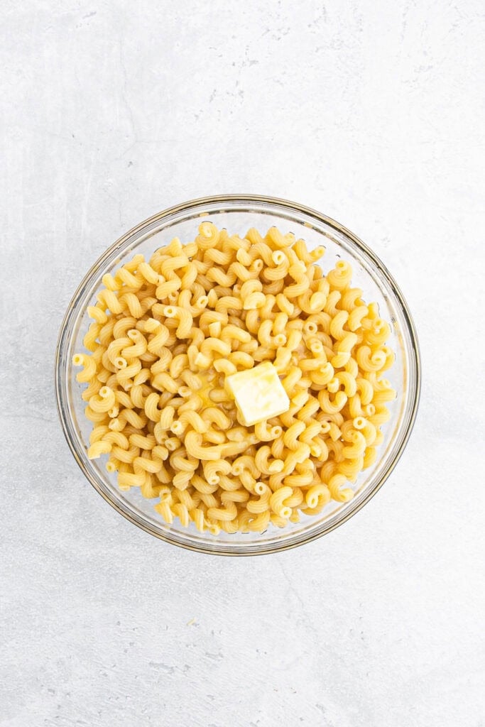 Butter and beaten egg in pasta in a bowl