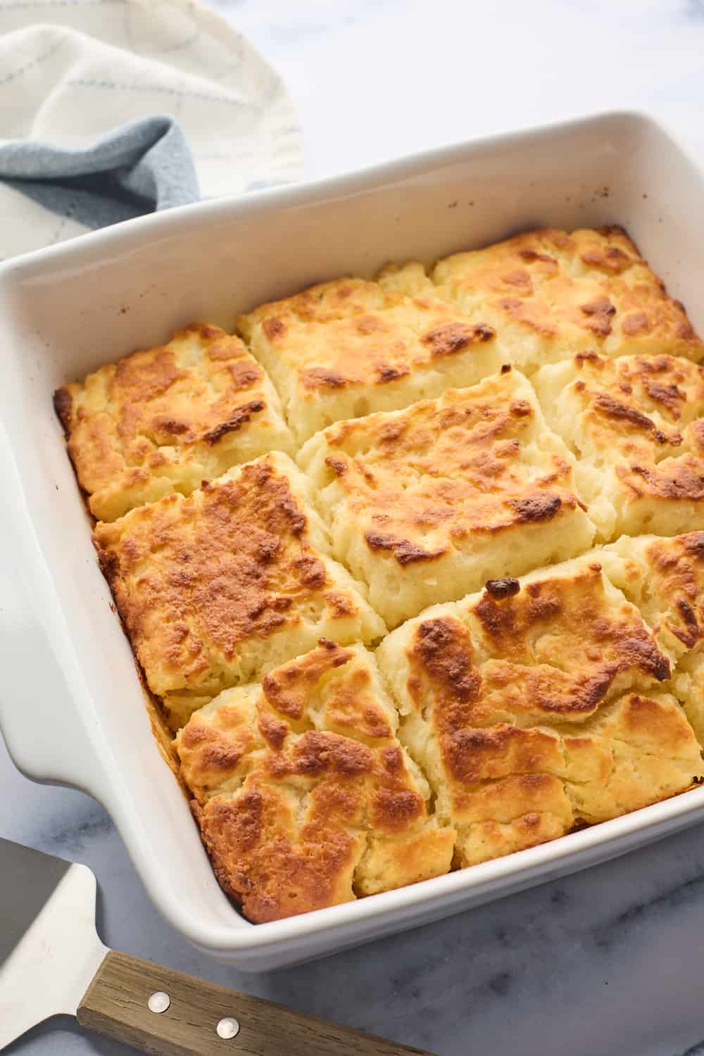 A full white pan of a butter swim biscuit recipe fresh out of the oven after baking on a white background